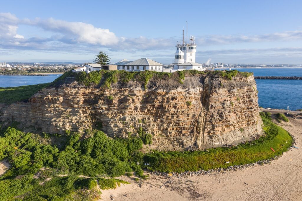 A Shartru Wealth aerial photo shows a lighthouse on a rocky cliff.