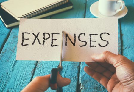 Shartru Wealth tip showing scissors cutting expenses to reduce costs and fight inflation effectively.
