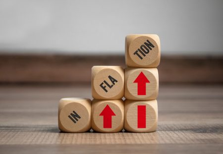 Stacked wooden blocks spelling inflation with red arrows, Shartru Wealth explains common inflation misconceptions.