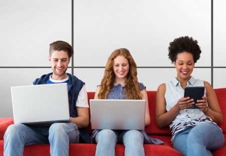 Shartru Wealth image of three young adults sitting on a red couch using laptops and a tablet.