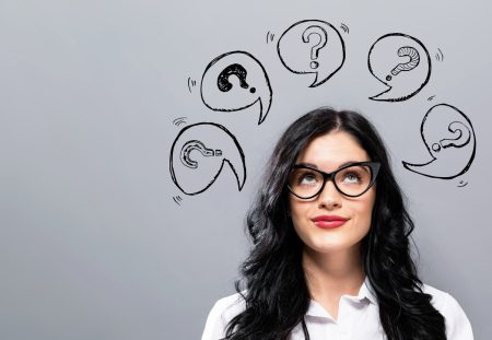 A person from Shartru Wealth looks up at a drawing of question marks in speech bubbles.