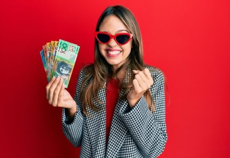 Young woman holding Australian dollars symbolises future investment opportunities with Shartru Wealth Management.