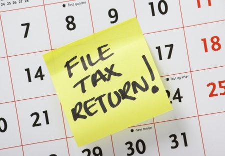 Shartru Wealth image of a calendar with a sticky note reminder to file tax return.