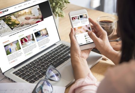 Shartru Wealth image of a woman shopping online using a laptop and smartphone at a desk.