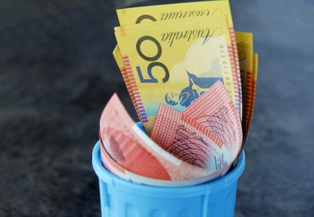 Shartru Wealth photo of Australian $50 and $100 banknotes placed inside a small bin.