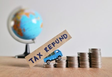 A Shartru Wealth visual shows a toy truck with "TAX REFUND" on a sign.