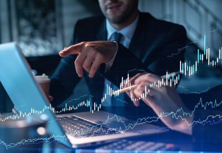 Shartru Wealth image of business professionals reviewing stock market data on a laptop screen.