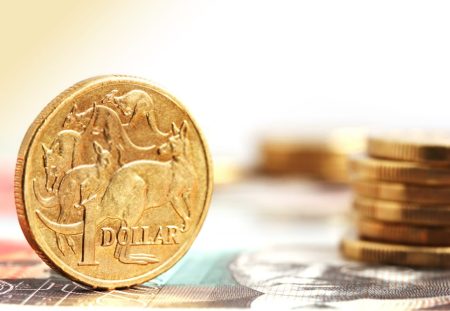 Australian one dollar coin with stacked money, Shartru Wealth explains dollar cost averaging strategy.