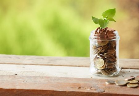 Jar of coins with plant sprouting, symbolising growing super contributions, Shartru Wealth Management.