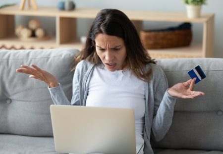 A photo from Shartru Wealth shows a person looking at a laptop, a credit card in hand.