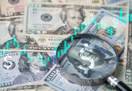 Shartru Wealth image of magnifying glass over US dollar bills with stock market chart overlay.