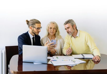 Shartru Wealth advisors meeting clients in a modern office setting.